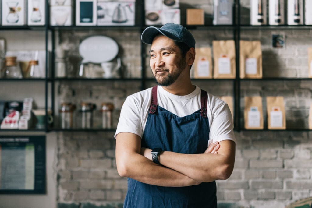 Standing tall and confident, this small business owner expertly operates his coffee roastery shop, producing top-quality beans.